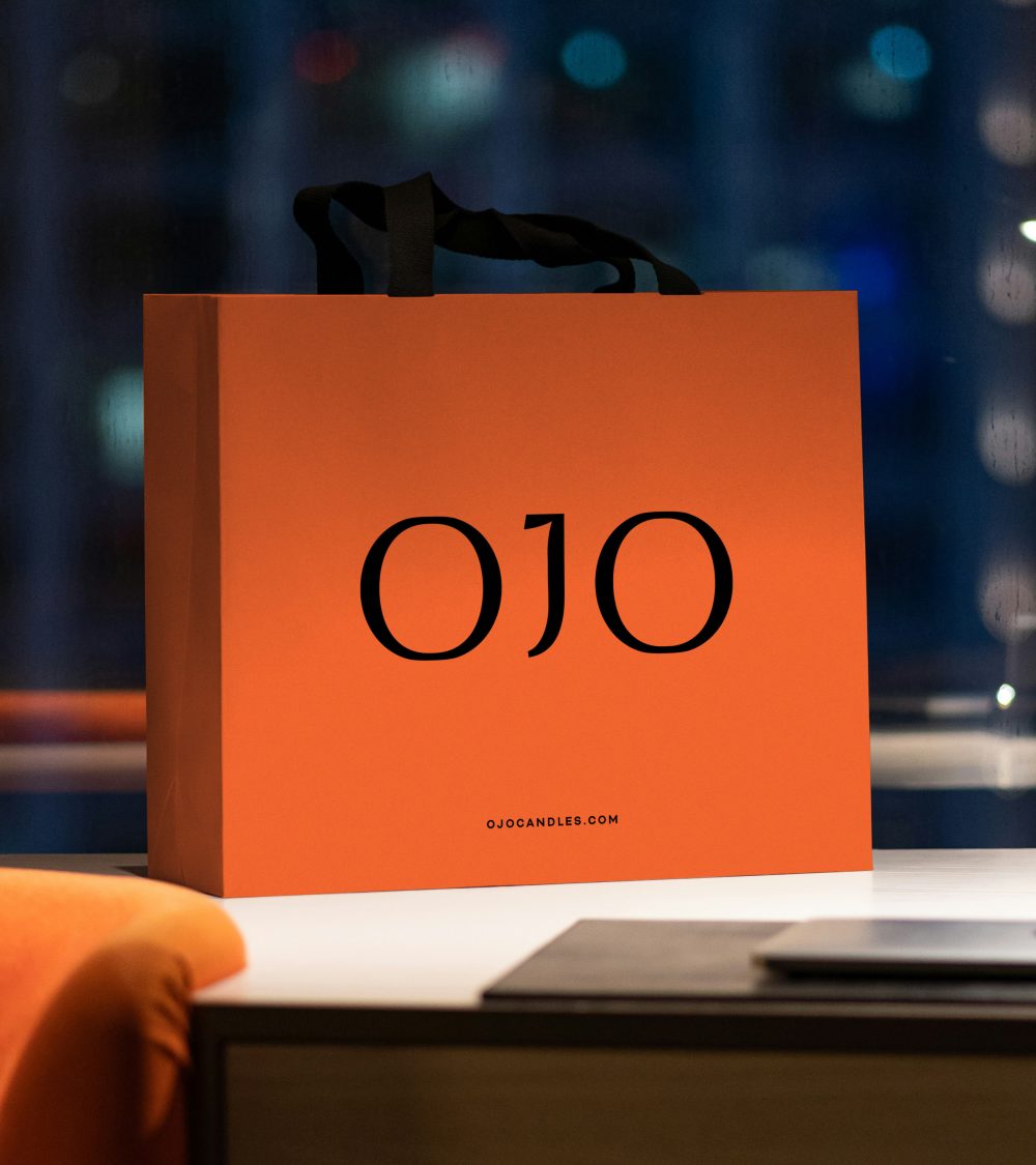 OJO brand identity design, orange shopping bag and dark blue background