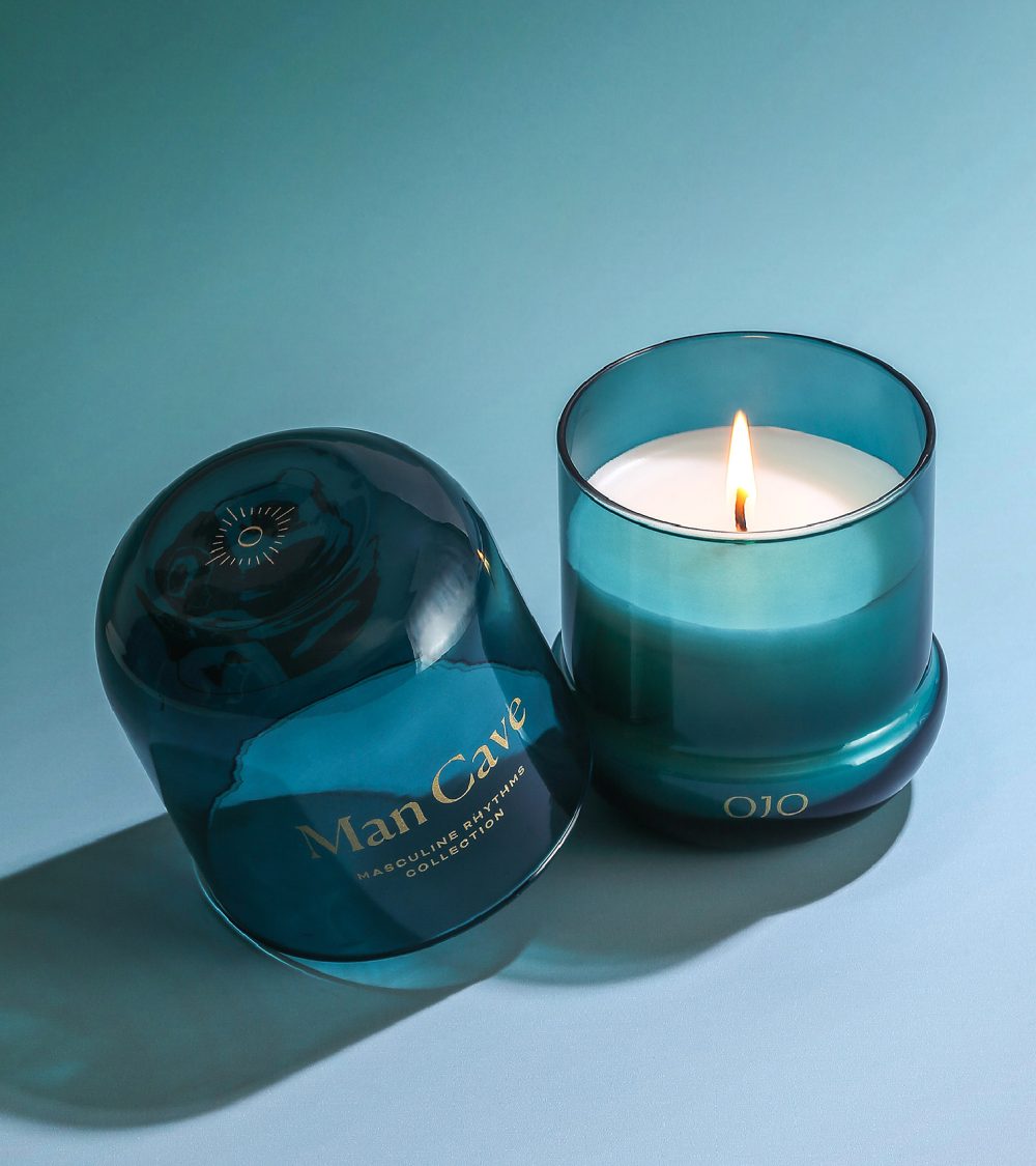 OJO Man Cave candle collection with blue green glass jar and blue background
