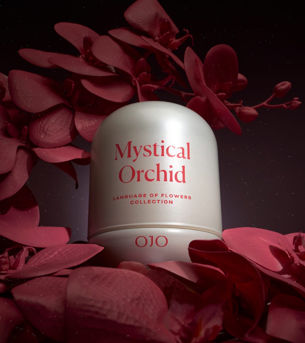 OJO Mystical Orchid candle with white glass jar and dark background with orchids