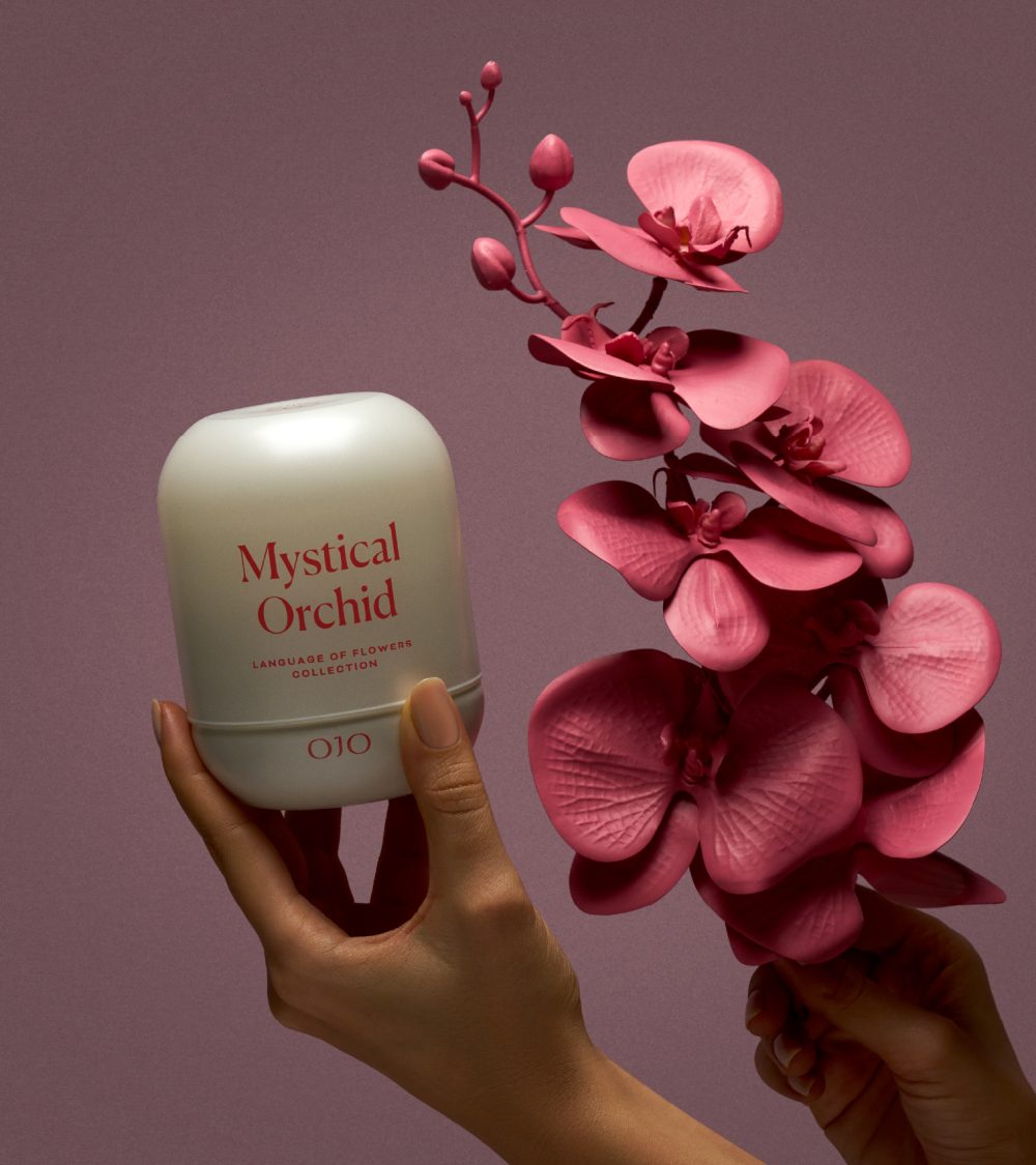 OJO Mystical Orchid candle with white glass jar, pink orchid flower and pink background
