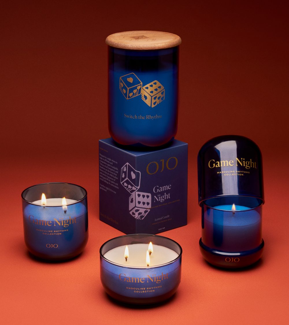 OJO Game Night candle collection with dark blue glass jars and orange background