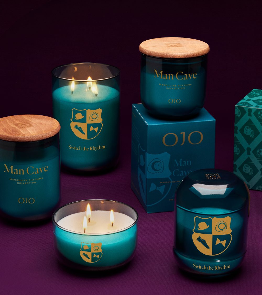 OJO Man Cave candle collection with dark green glass jars and purple background
